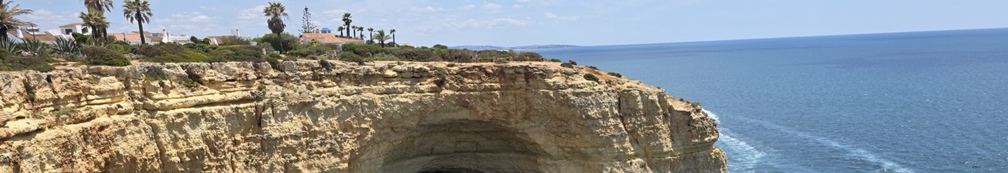 tour pirate ship moored outside arching cave and steep cliffs off the coast of Portugal